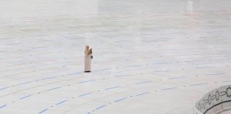 Hajj - une femme invoque seule devant une Kaaba généralement bondée
