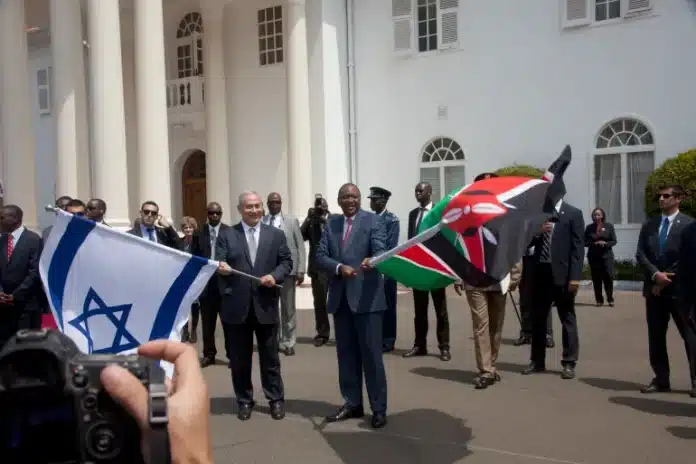 Benjamin Netanyahu tenant le drapeau israélien aux côtés d'Uhuru Kenyatta avec le drapeau kényan à Nairobi, juillet 2016.