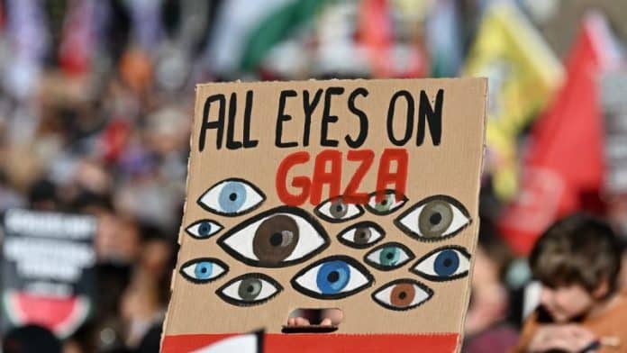 Manifestation à Berlin le 27 septembre 2025, participant tenant une pancarte « All Eyes on Gaza ».