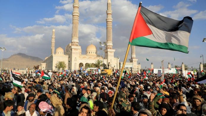 Manifestation de soutien aux Palestiniens à Gaza au Yémen, drapeaux et banderoles visibles.